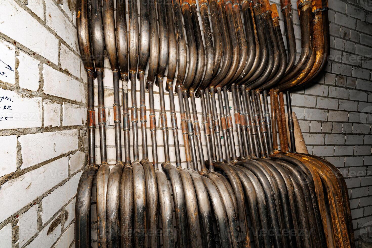 Vertical Symphony An Array of Industrial Metal Tubes Elegantly Intertwined with the Rustic Texture of Brick. photo