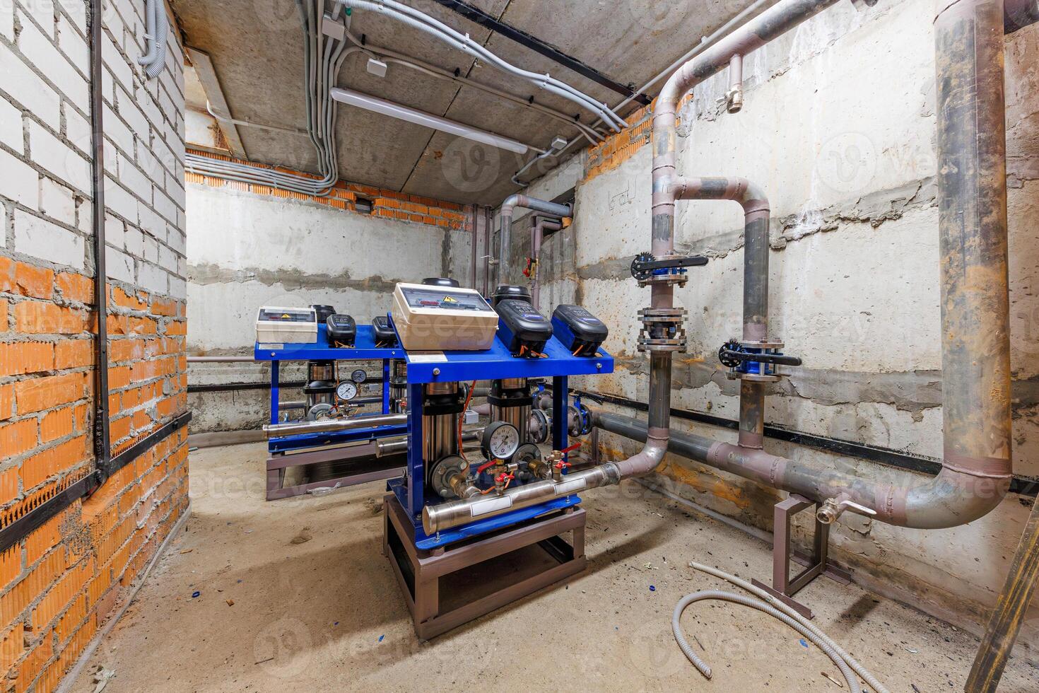 Symphony of Mechanics A captivating arrangement of blue pump units and intricate piping in a bustling mechanical room. photo