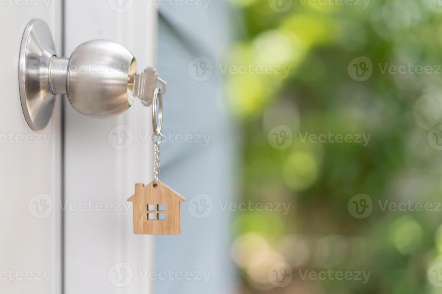 key for unlocking house is plugged into the door. Second hand house for rent and sale. keychain is blowing in the wind. mortgage for new home, buy, sell, renovate, investment, owner, estate photo