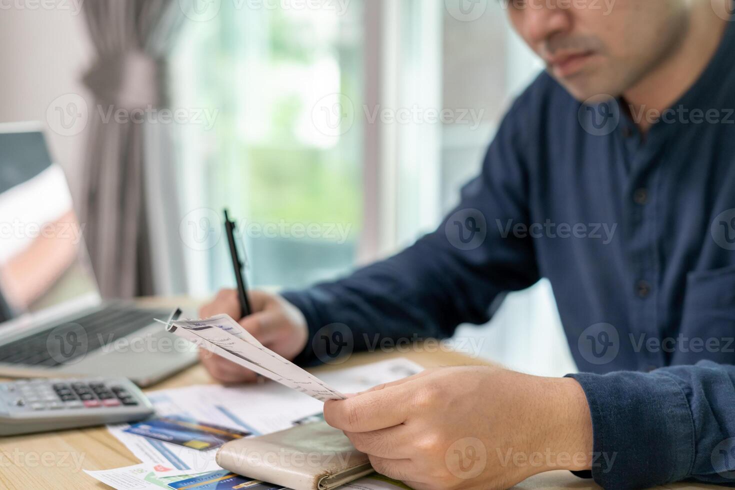 asian man with large bills or invoices no money to pay to expenses and credit card debt. shortage, Financial problems, mortgage, loan, bankruptcy, bankrupt, poor, empty wallet photo