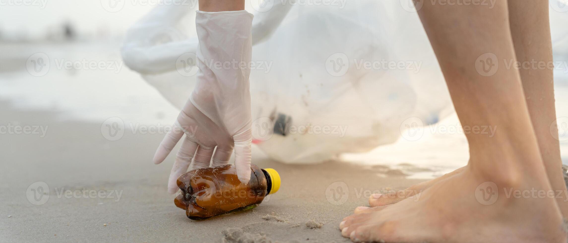 Volunteer pick trash garbage at the beach and plastic bottles are difficult decompose prevent harm aquatic life. Earth, Environment, Greening planet, reduce global warming, Save world photo