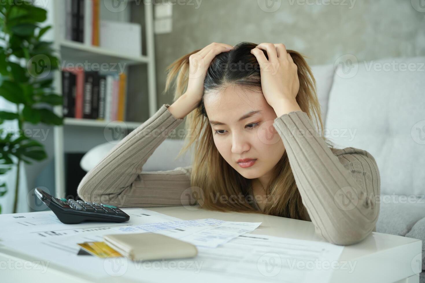 asian woman with large bills or invoices no money to pay to expenses and credit card debt. shortage, Financial problems, mortgage, loan, bankruptcy, bankrupt, poor, empty wallet photo