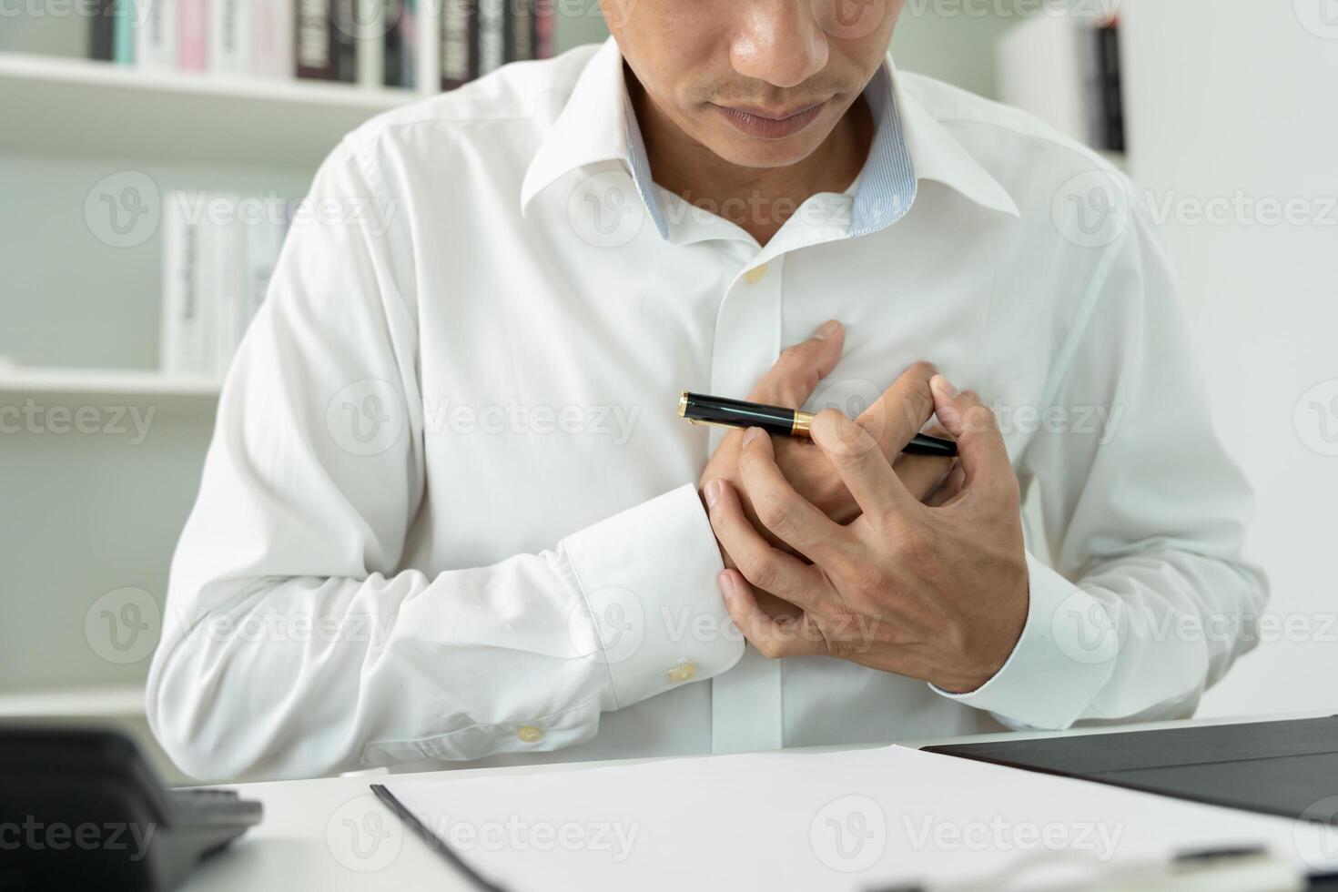 heart attack symptoms, asian man working hard have chest pain caused by heart disease, leak, dilatation, enlarged coronary heart, press on the chest with a painful expression photo