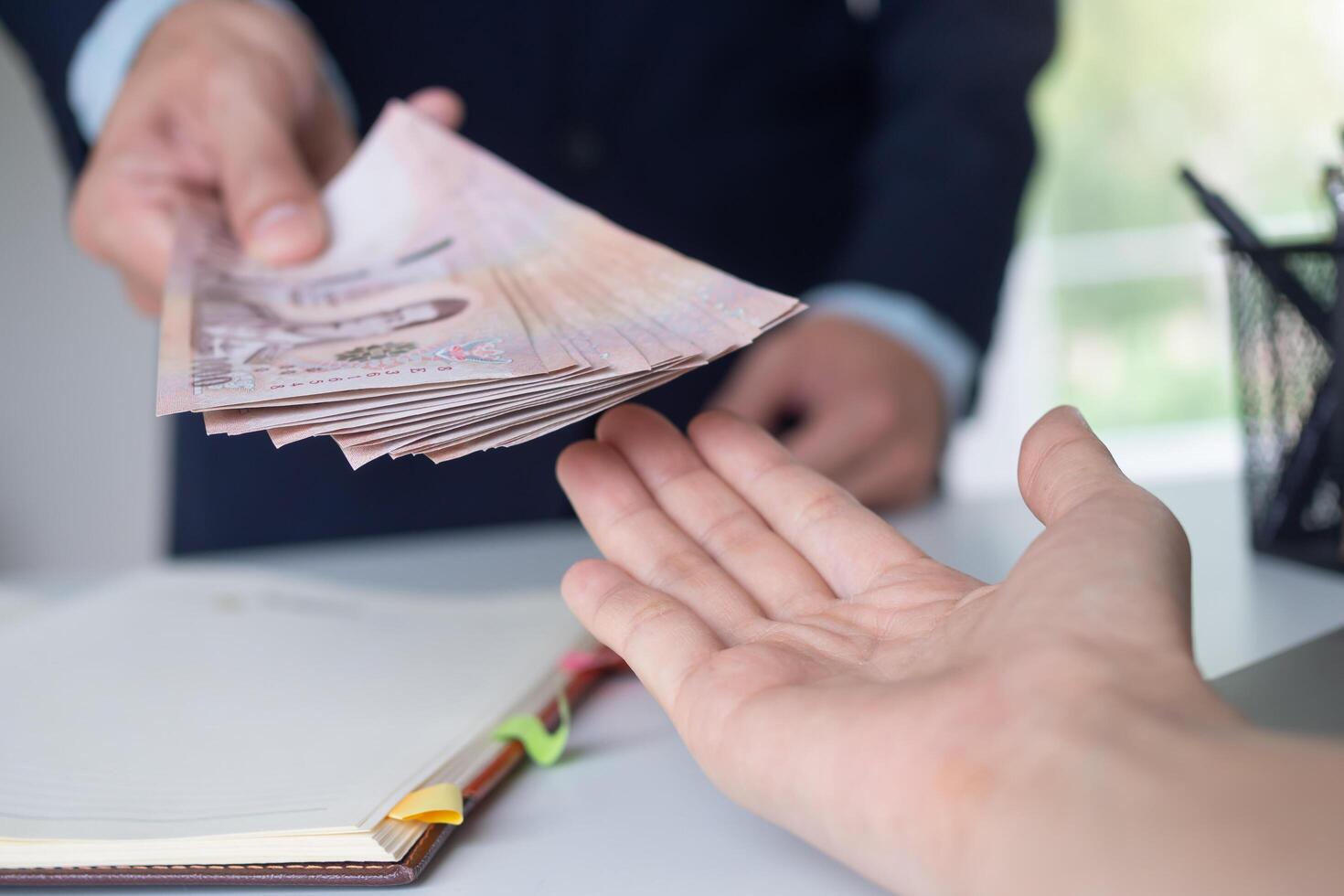 receive salary or bonuses from management or Boss. Company give rewards to encourage work. Smiling businessman enjoying a reward at the desk in the office. photo