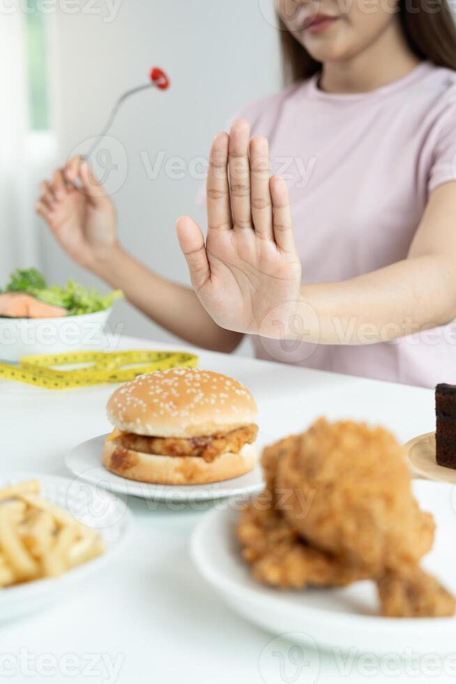 Beauty slim female body confuse hamburger. Woman in restaurant achieves weight loss goal for healthy life, crazy about thinness, thin waist, nutritionist. Diet, body shape photo