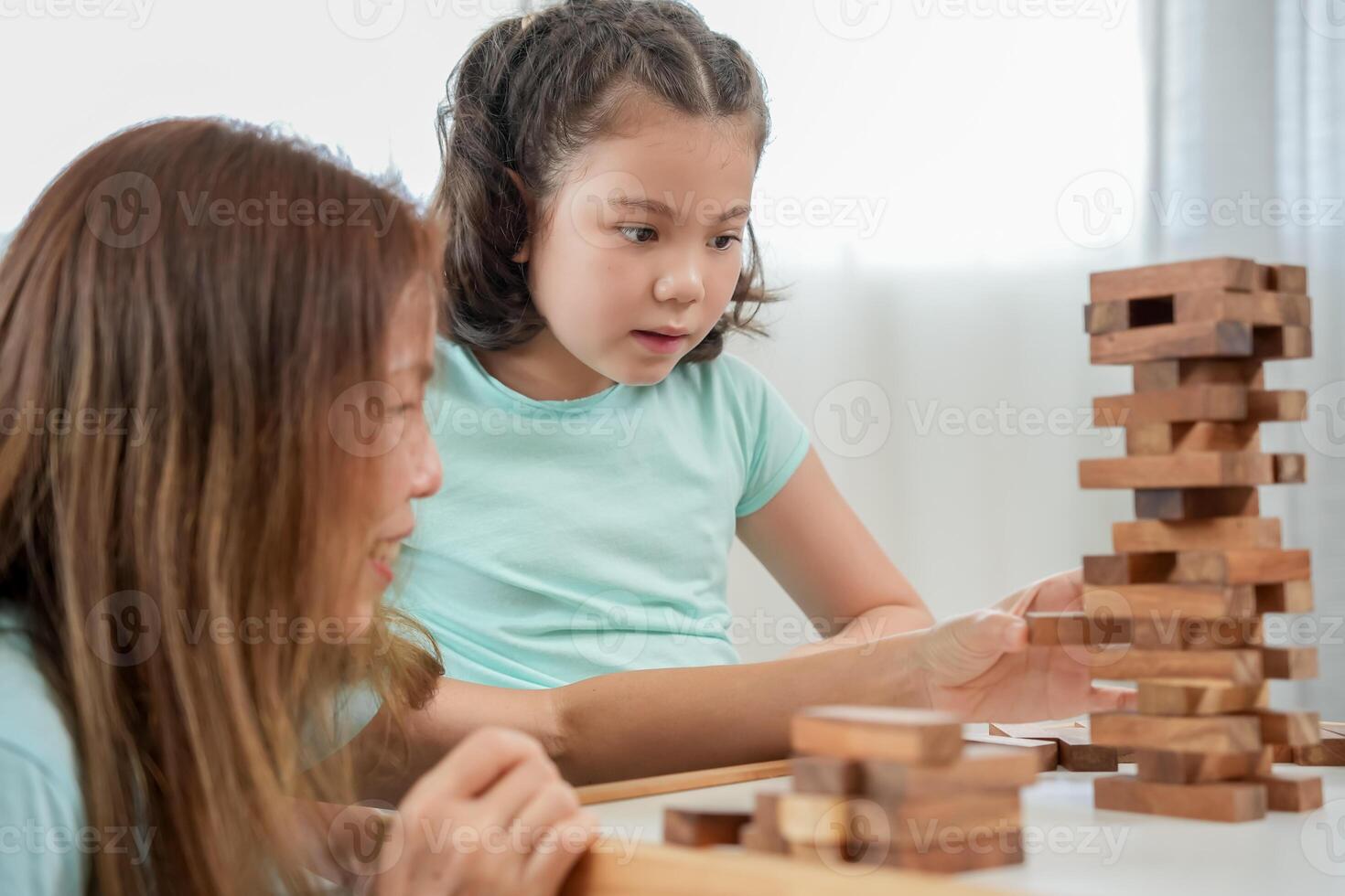 mother playing learning games jan-ga with the little girl. Funny family is happy and excited in the house. mother and son having fun spending time together. holiday, weekend, vacant. photo