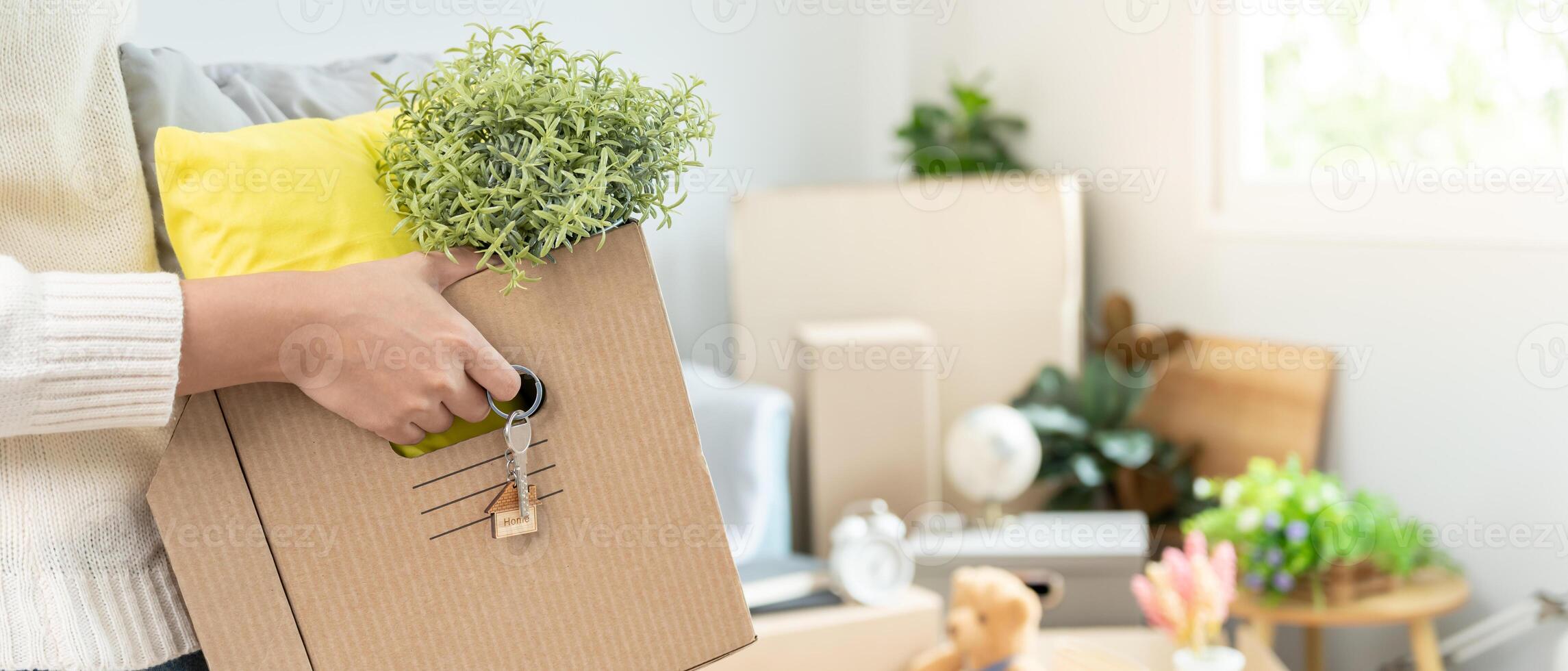Moving house, relocation. Woman hold carton box contain equipment for new condominium, inside the room was a cardboard box containing personal belongings and furniture. photo
