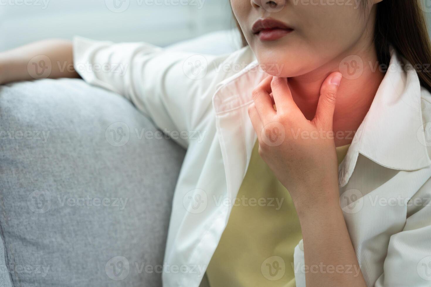 Asian woman put her hand on her neck due to a sore throat. female tonsillitis causes a inflammation. treated by taking water, taking antibiotics, consult a doctor, virus, corona virus, Influenza, flu. photo