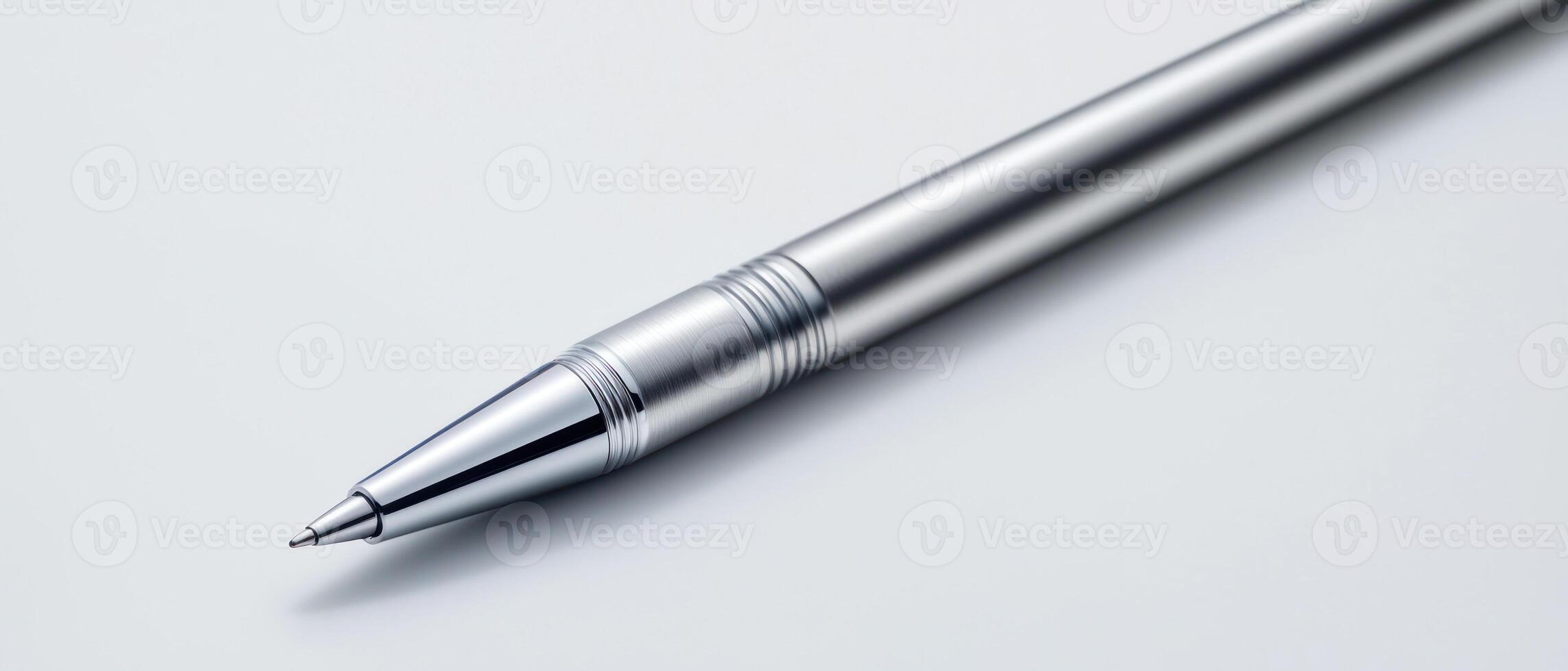 sleek silver pen resting on smooth surface, ideal for writing photo