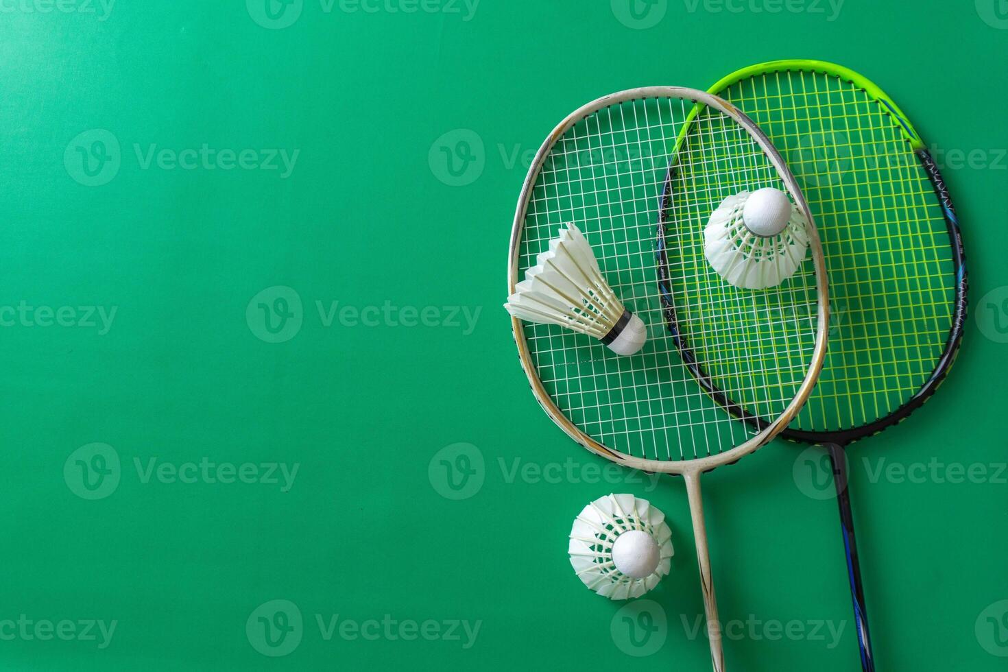 Flat lay of badminton rackets and shuttlecocks on a vibrant green background photo