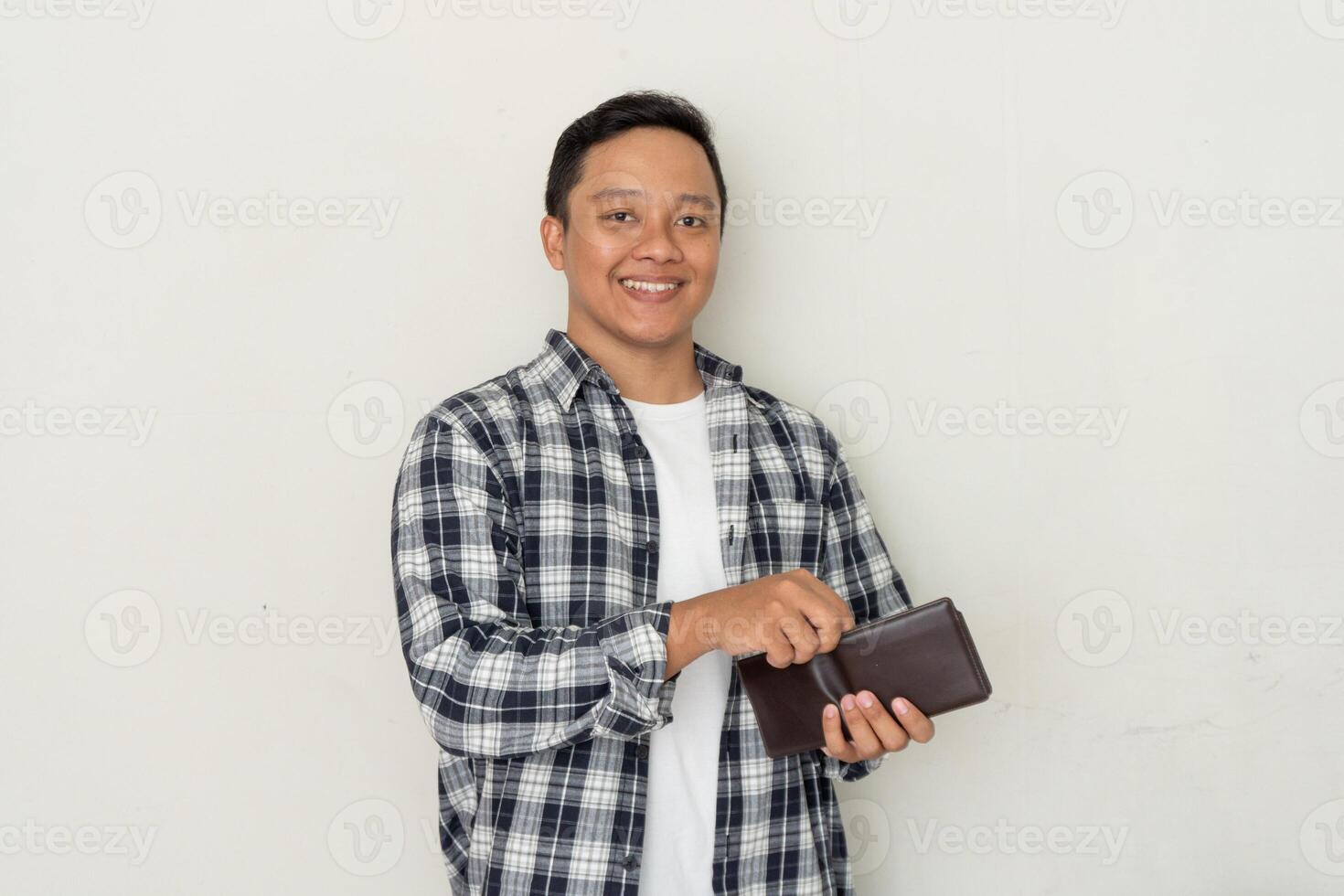 Handsome Asian man take out his money from the wallet with happy expression. Man smiling while holding his wallet photo
