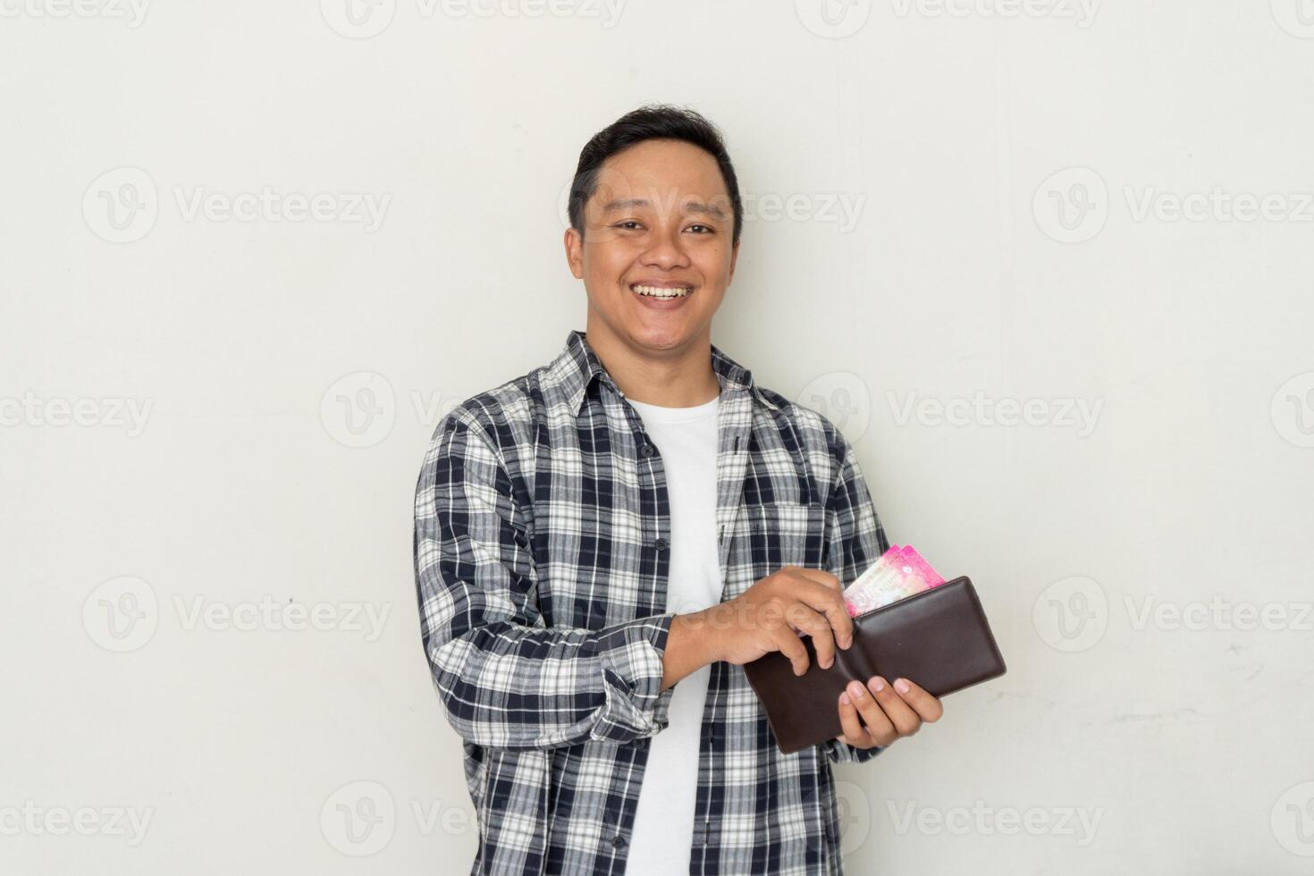 Young Asian man take out his money from the wallet with happy expression. photo