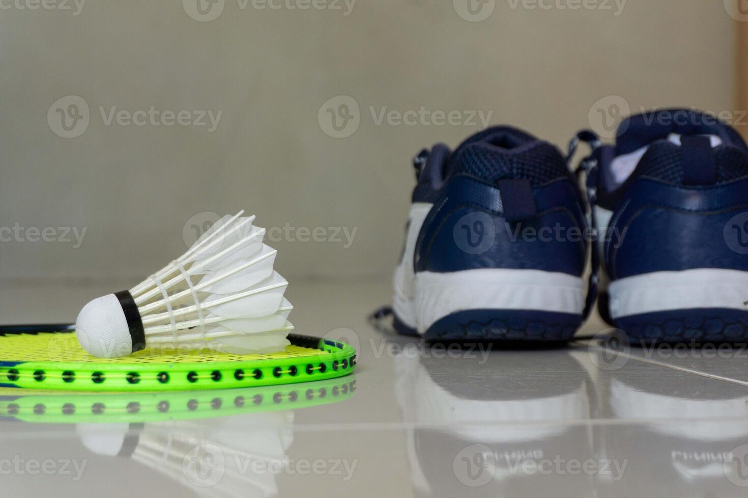 Set of badminton equipment with rackets, shoe, and shuttlecocks on a floor photo