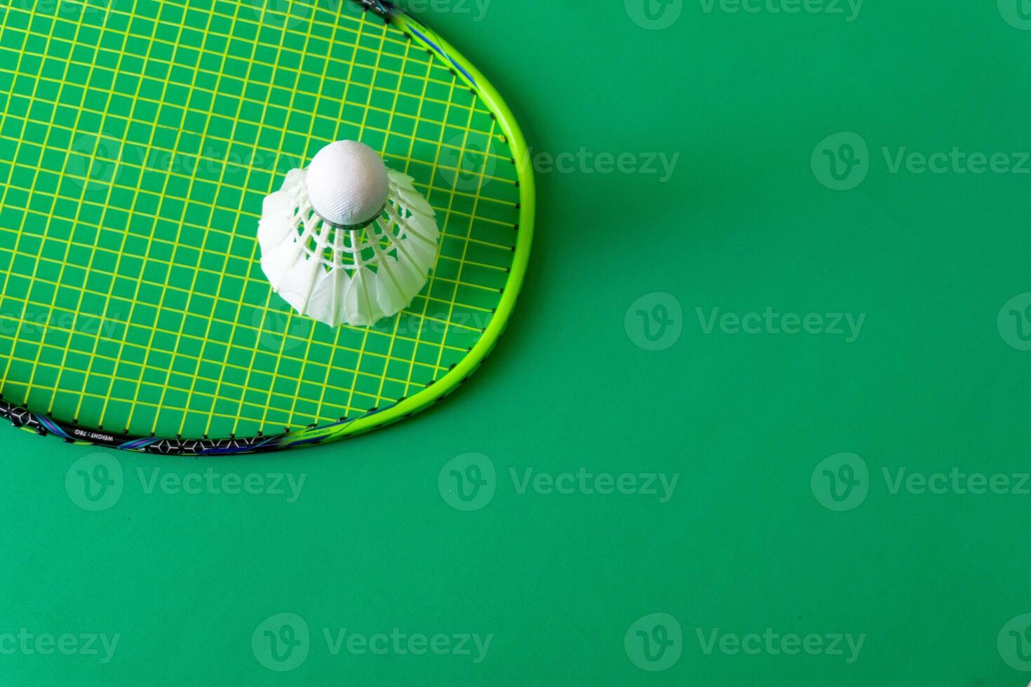 racket and shuttlecock on green background photo