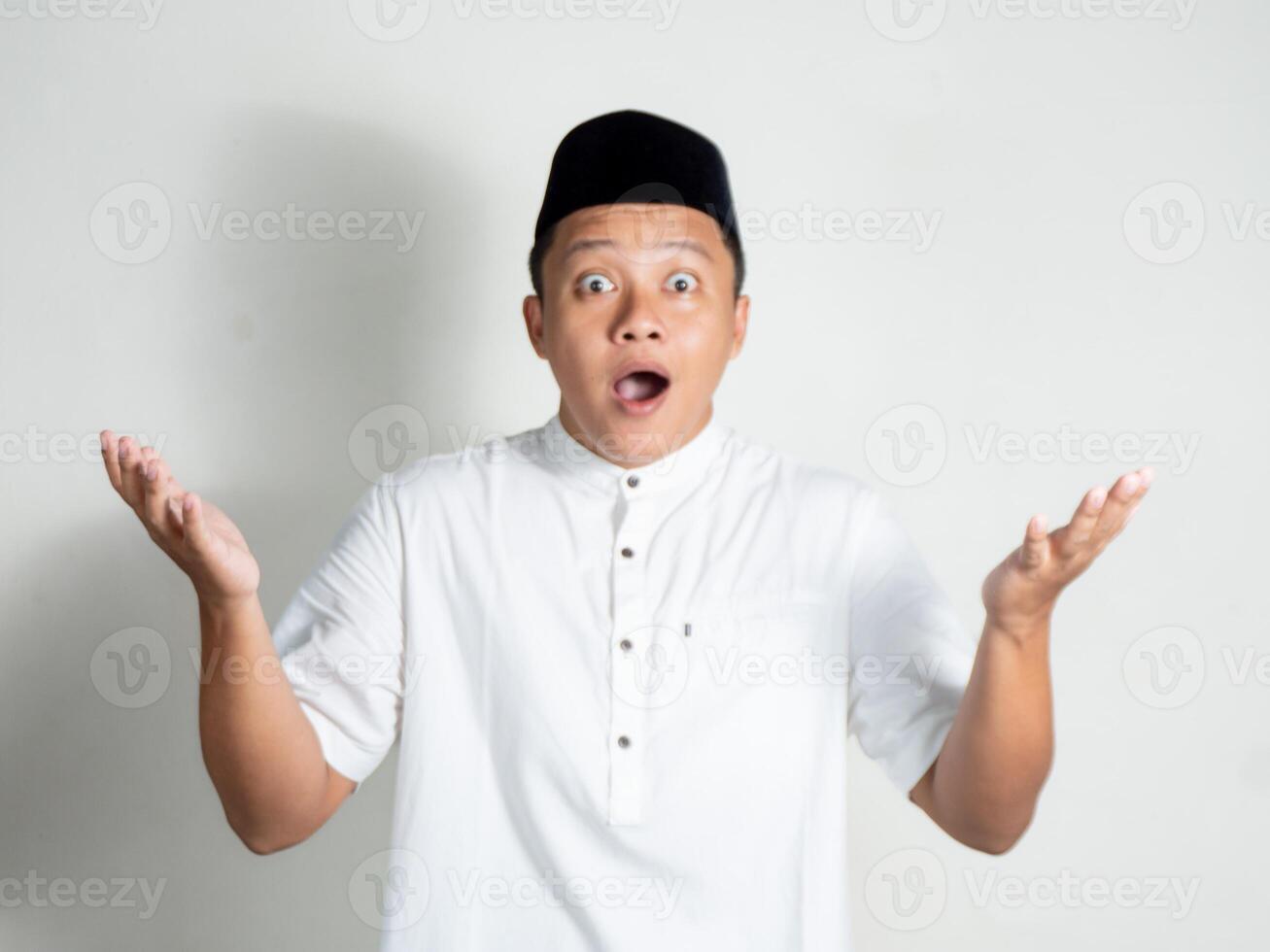 Muslim Asian man shows shocked and surprised expression while open up his hand photo
