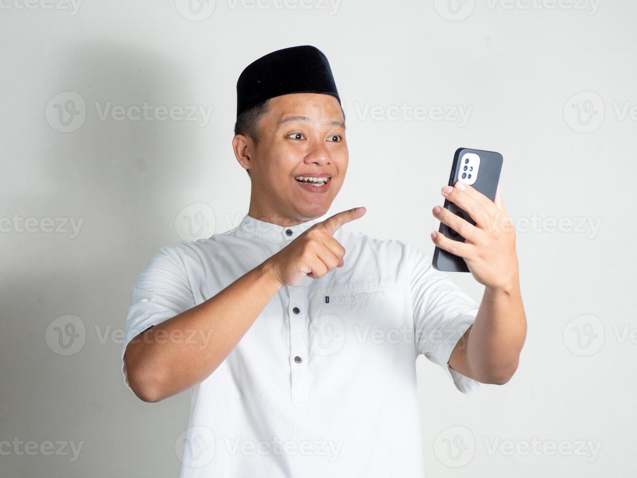 Muslim Asian man shows shocked and surprised expression while mobile phone photo