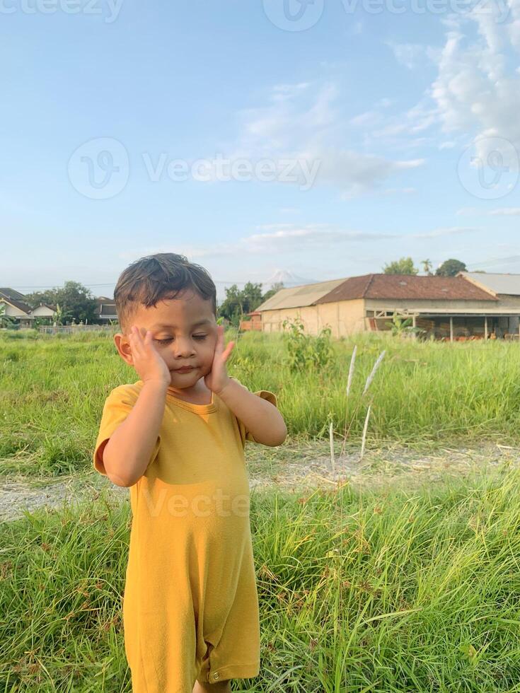 little boy is playing in high weed, photo