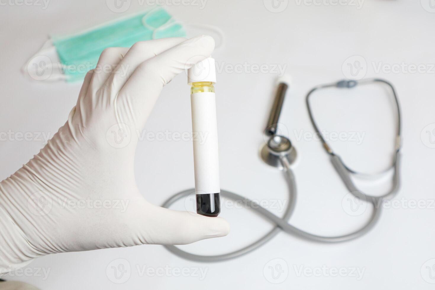 Laboratory hand in rubber glove holding test tube with blood sample on light background with space for text photo