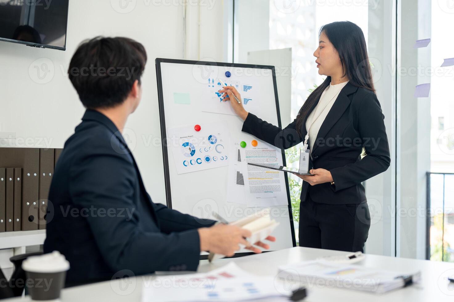 A focused and confident Asian businesswoman explains her project to everyone in the meeting. photo