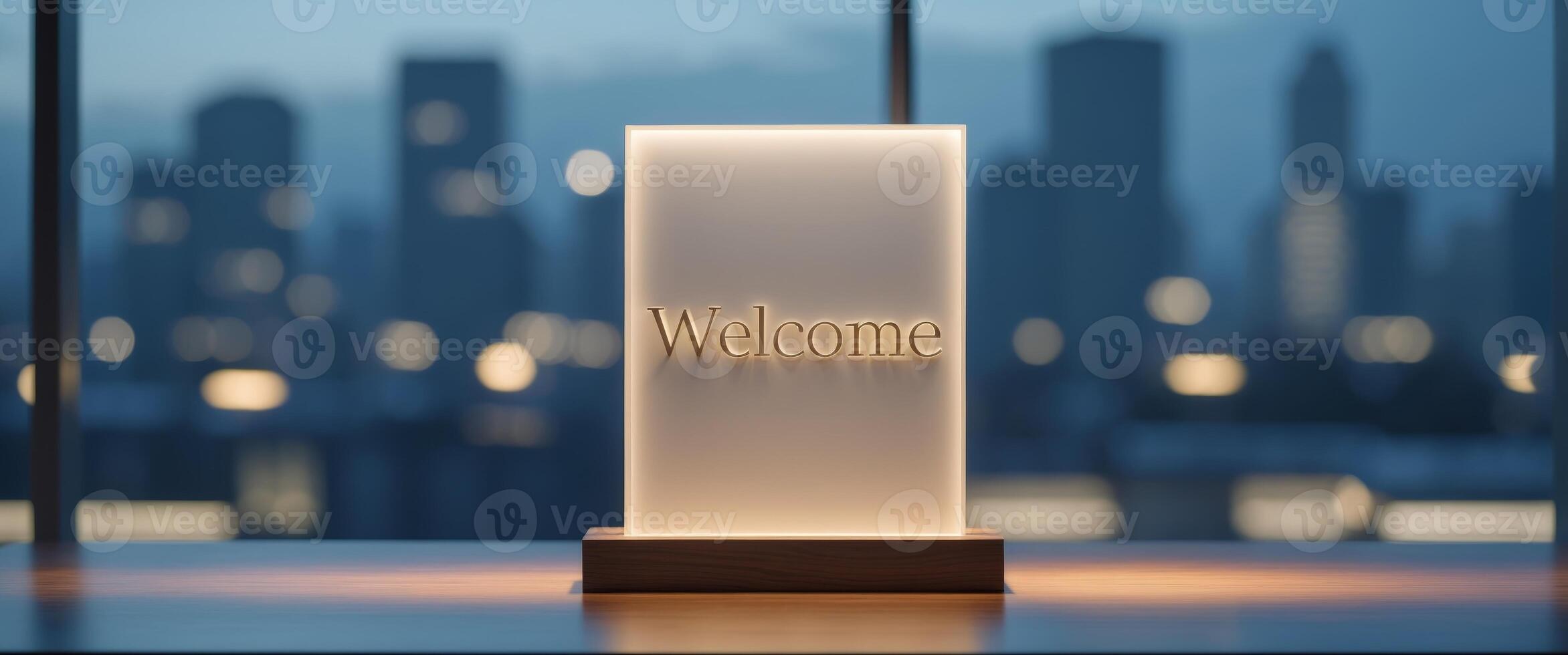 Warm illuminated welcome sign on an elegant wooden desk with evening city lights in the background. photo