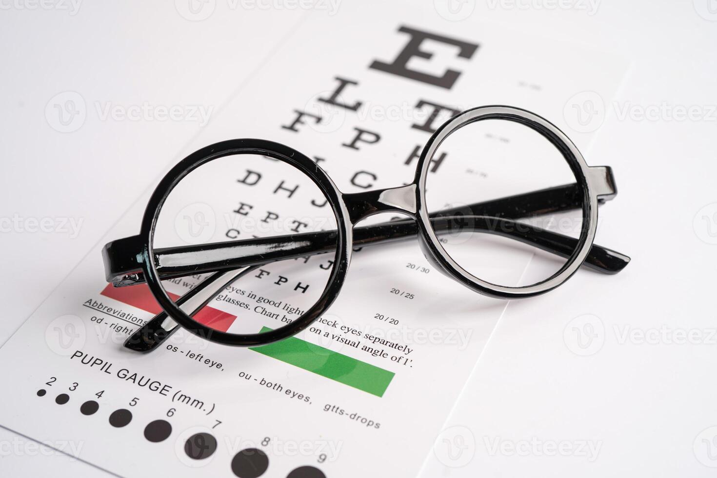 Glasses on eye testing exam chart to check eyesight accuracy photo