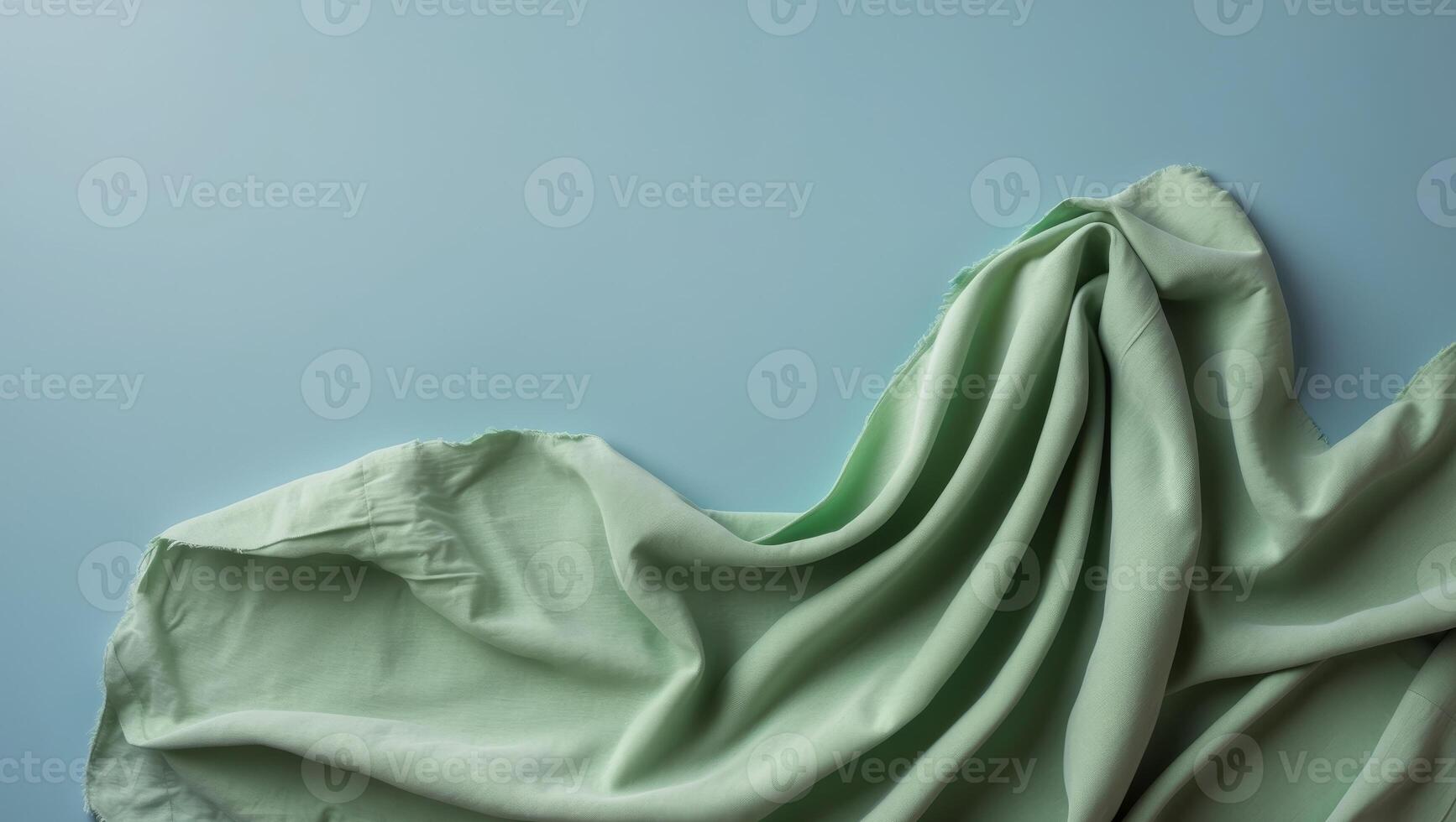 A blue background with a green fabric draped over it. photo
