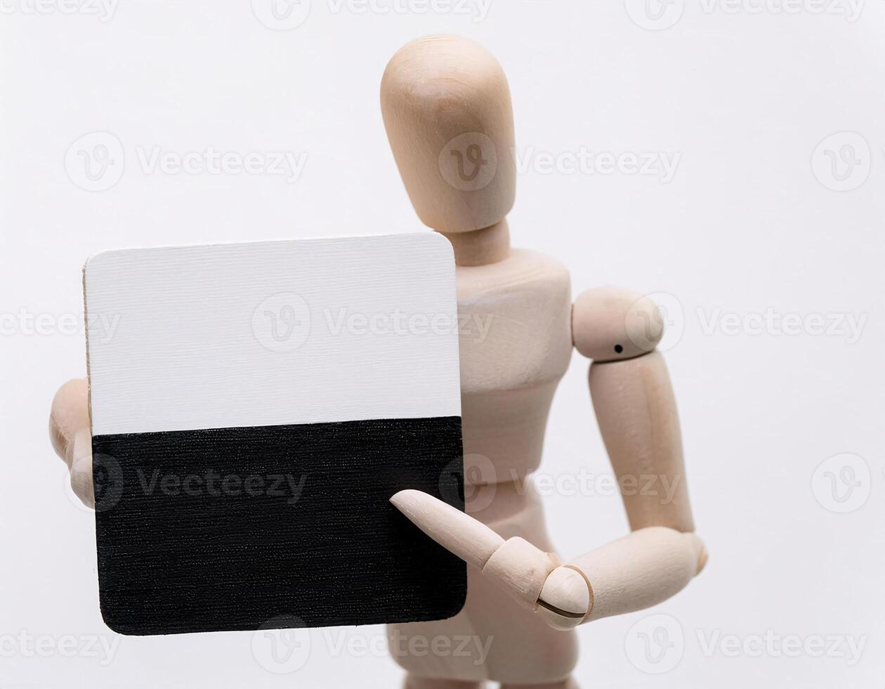 Minimalist Wooden Figure Pointing at Plaque with Contrasting Colors photo