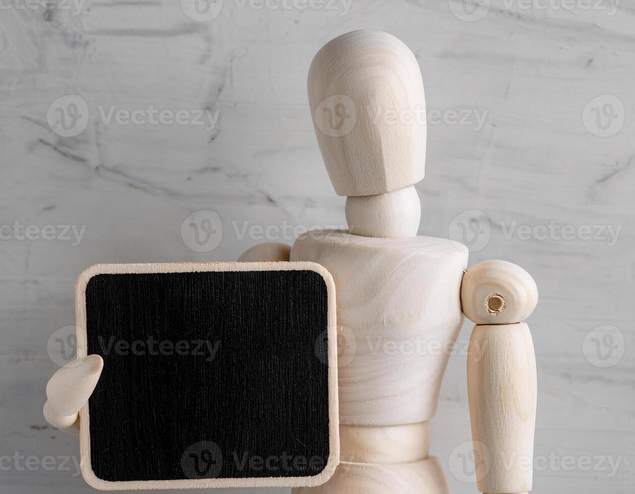 Wooden Man Figure with a White and Dark Plaque, Directional Gesture photo