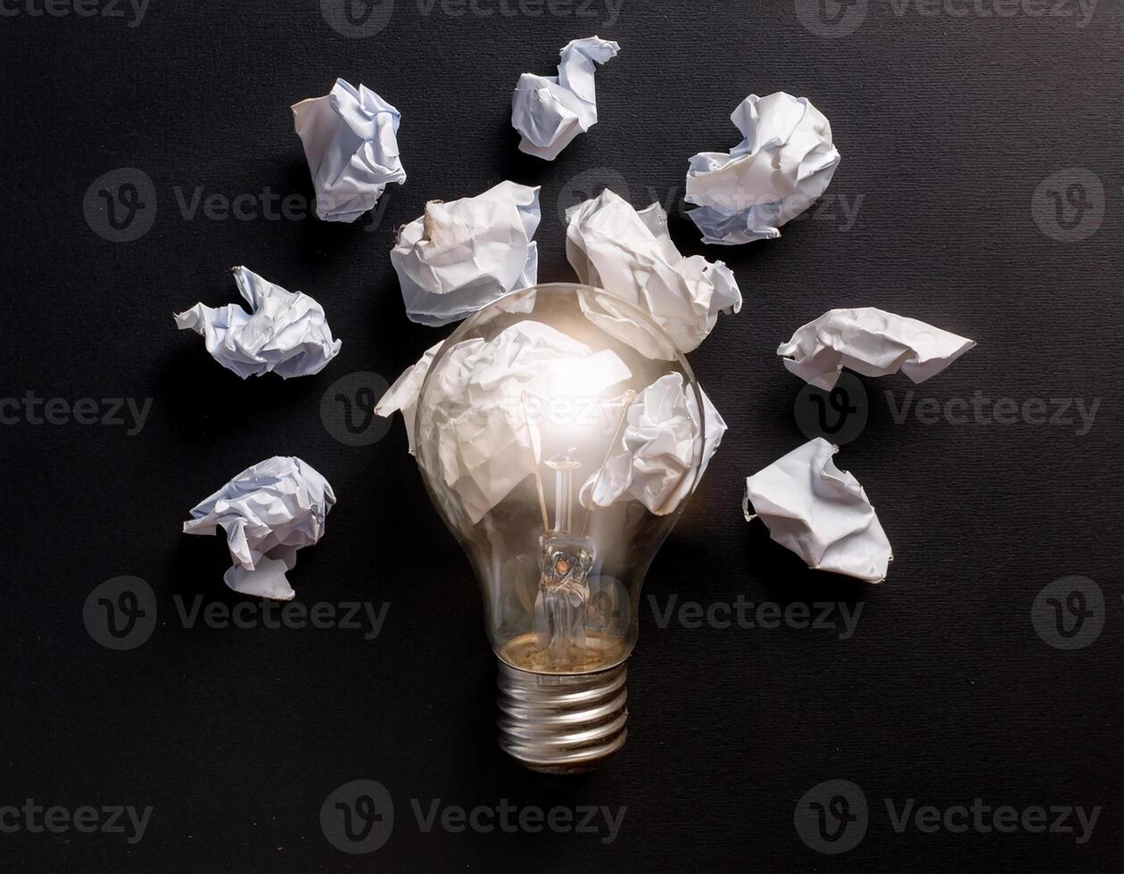Creative Idea Concept with Lamp and Crushed Paper on Black Background photo