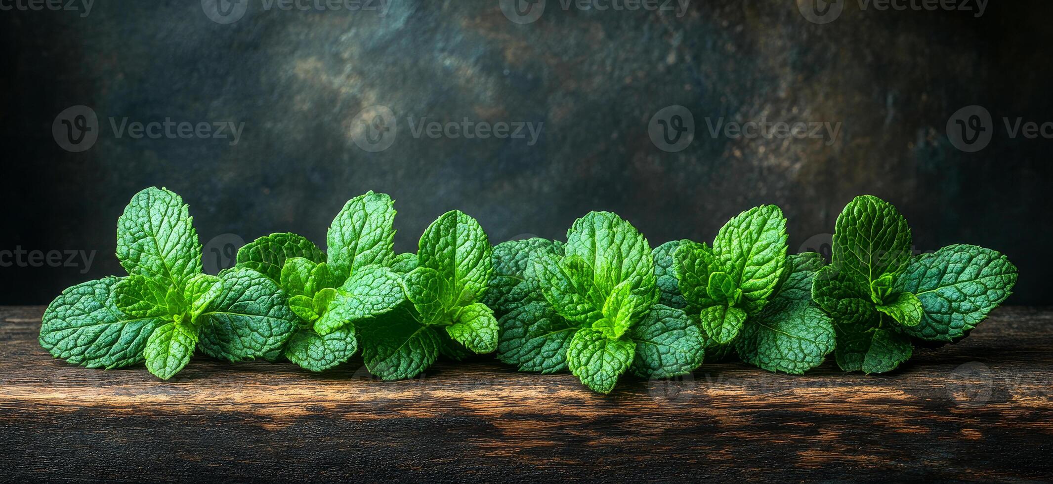 Mint leaves on wood surface. Bright green mint leaves are neatly lined up on a rustic wooden surface, showcasing their vibrant color and texture. photo