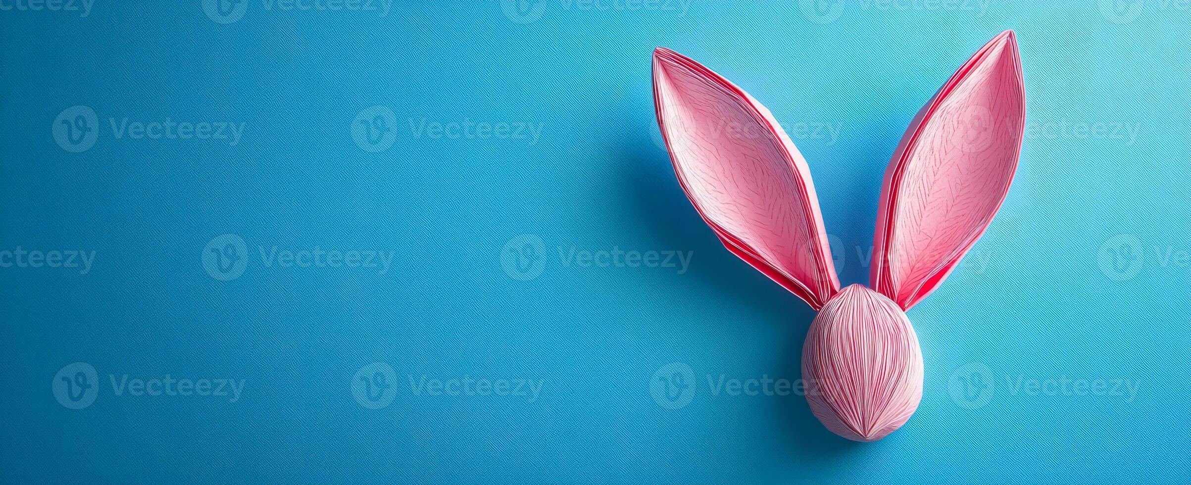 Bunny ears Easter egg design. A colorful egg with pink bunny ears set against a bright blue background, capturing a festive Easter theme. photo