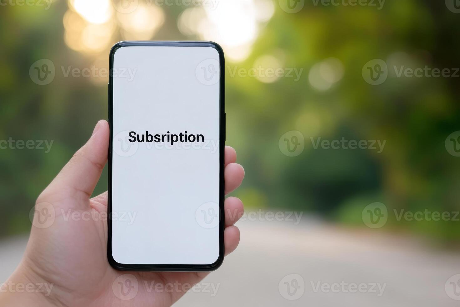Hand holding smartphone displaying subscription details in a natural outdoor setting during daylight hours photo