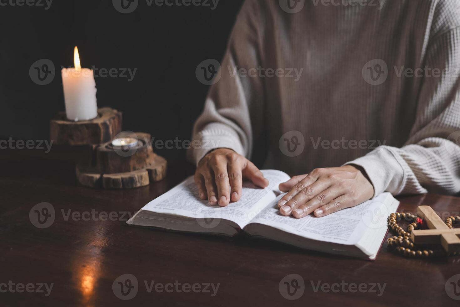 Hand of woman while praying for christian religion, Casual woman praying with her hands together over a Bible with faith. photo