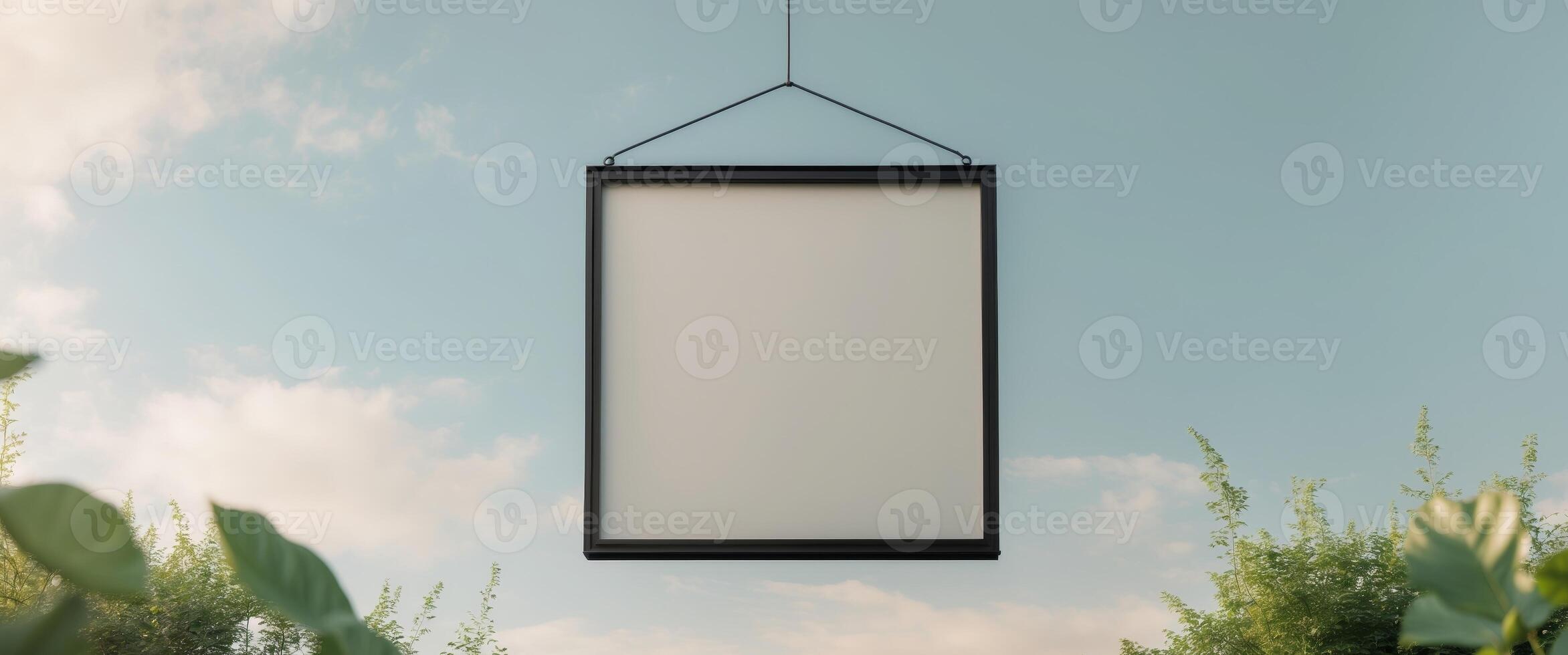 Blank hanging signboard with a black frame in an outdoor setting photo
