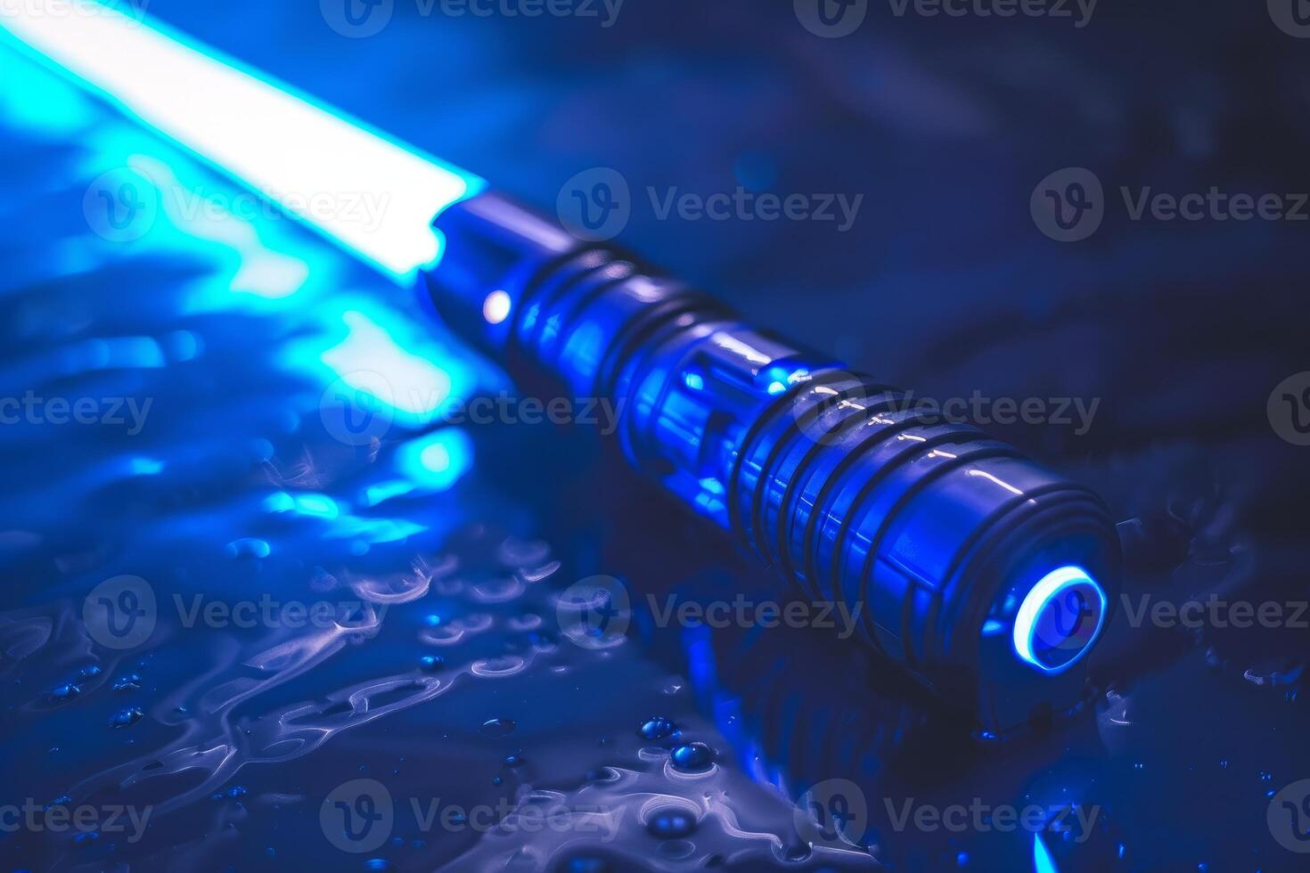 Blue light saber resting on wet surface reflecting light photo
