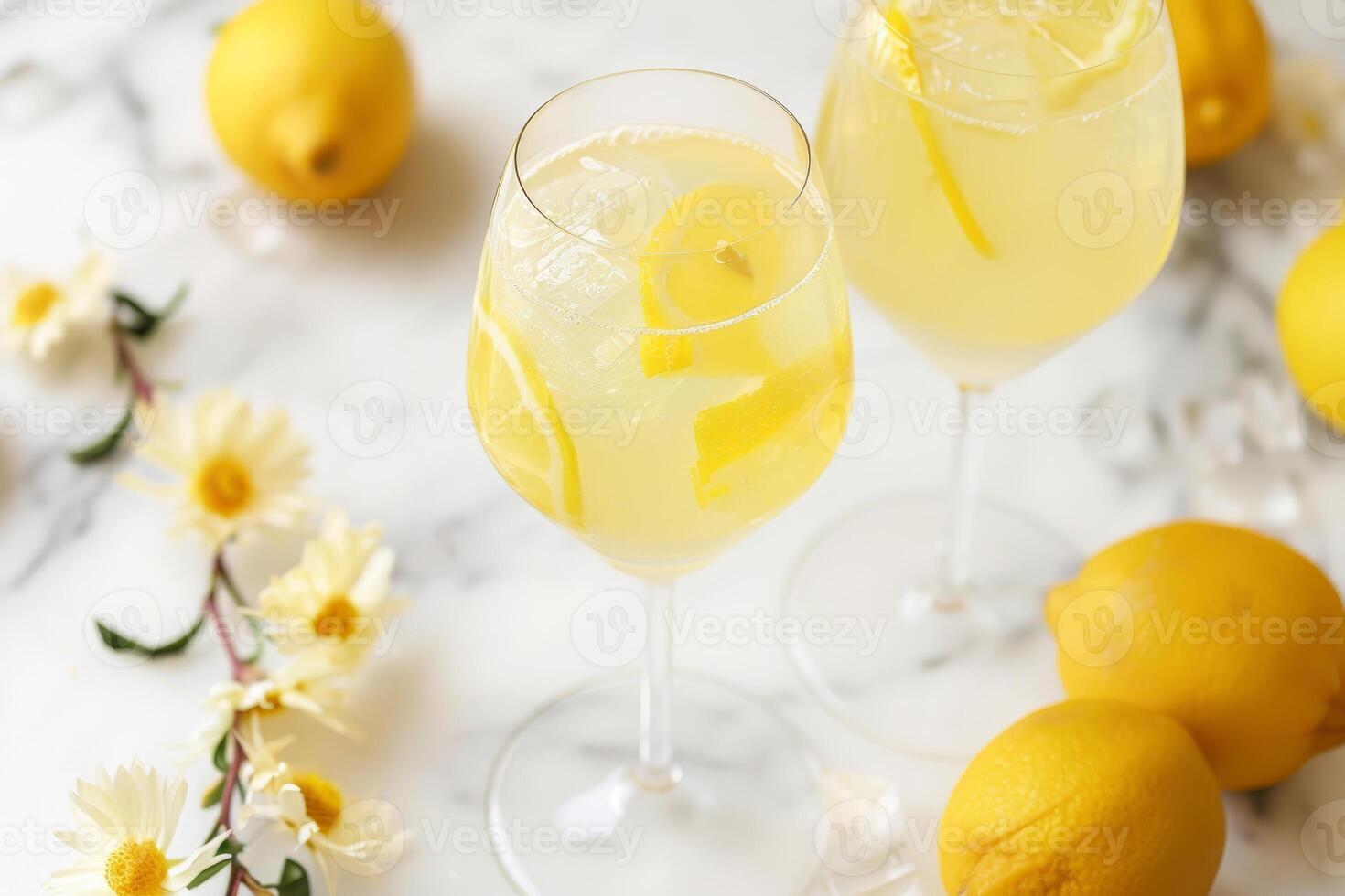 Refreshing lemonade cocktails with ice and lemon slices on marble table photo