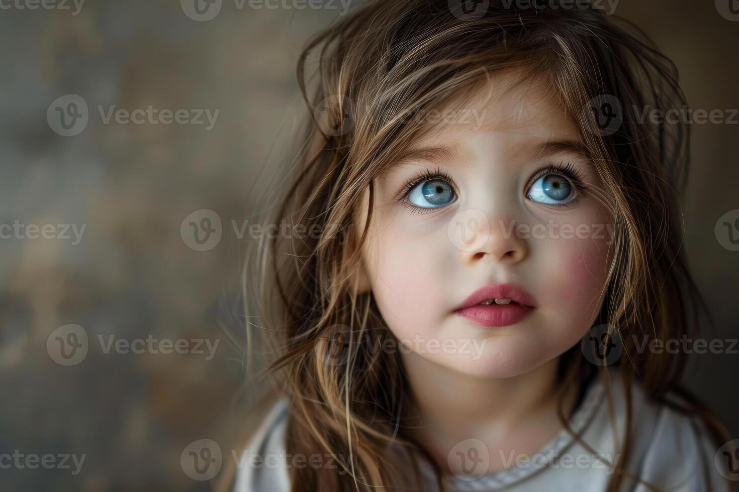 Portrait of cute little girl with big blue eyes looking up with hope photo