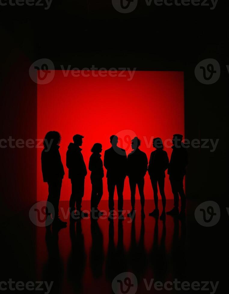 A group of people standing in front of a red light photo