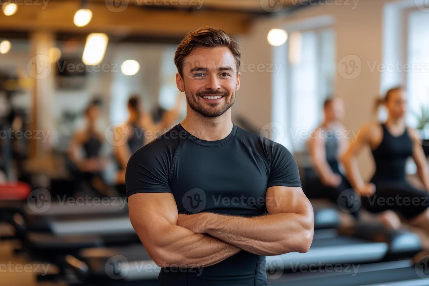 Fitness trainer in a modern gym with arms crossed photo