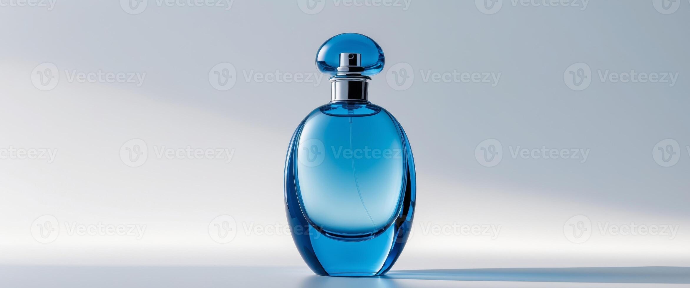 Elegant blue glass perfume bottle stands out with its unique shape and smooth design on a clean background. photo