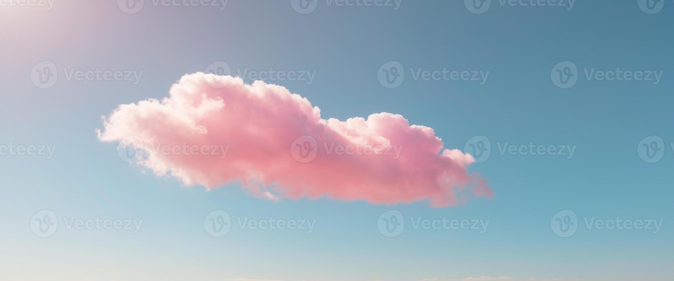 Fluffy pink cloud drifting across a bright blue sky on a sunny and cheerful day photo
