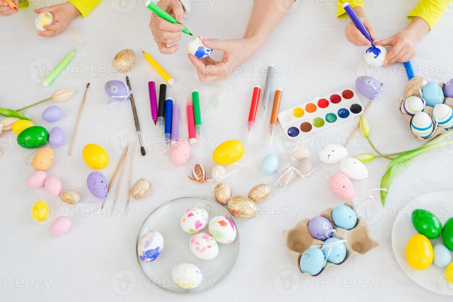 Happy Easter. Little girls grandmother hands painting eggs enjoying time together. Happy family preparing for Easter. Table with colorful painting eggs decorations. Spring Christian festival tradition photo