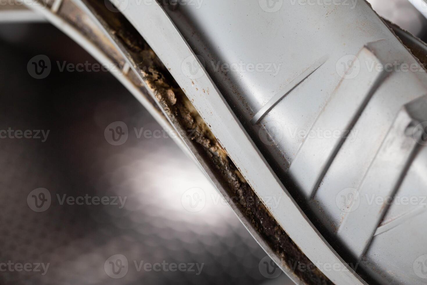 Dirt, mildew and mold in the hatch seals of the washing machine. Unsanitary and unpleasant smell. Cleaning and repairing stains in the washing machine photo
