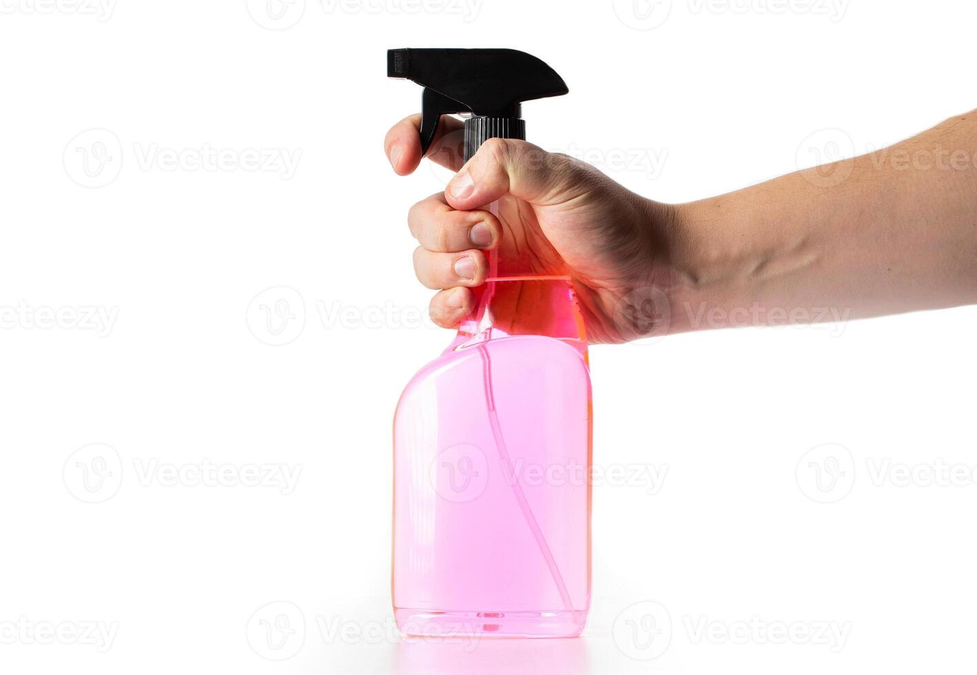 A bottle with a spray and pink liquid in a man's hand on a white background, isolate. Anti-ice, ice and lock defroster photo