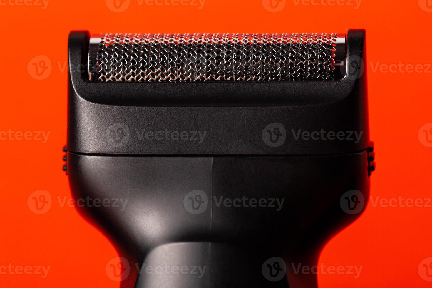 Modern shaving head on a red background. Beard care, close-up photo