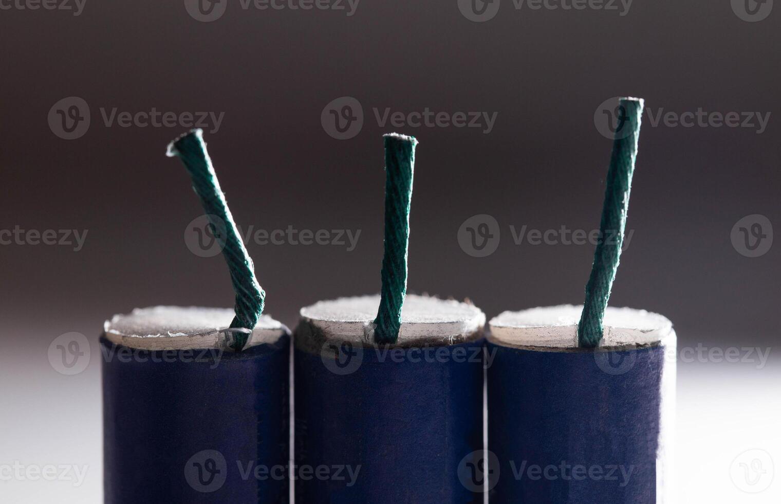Three blue firecrackers with a wick, close-up. Safety concept for pyrotechnic explosions photo