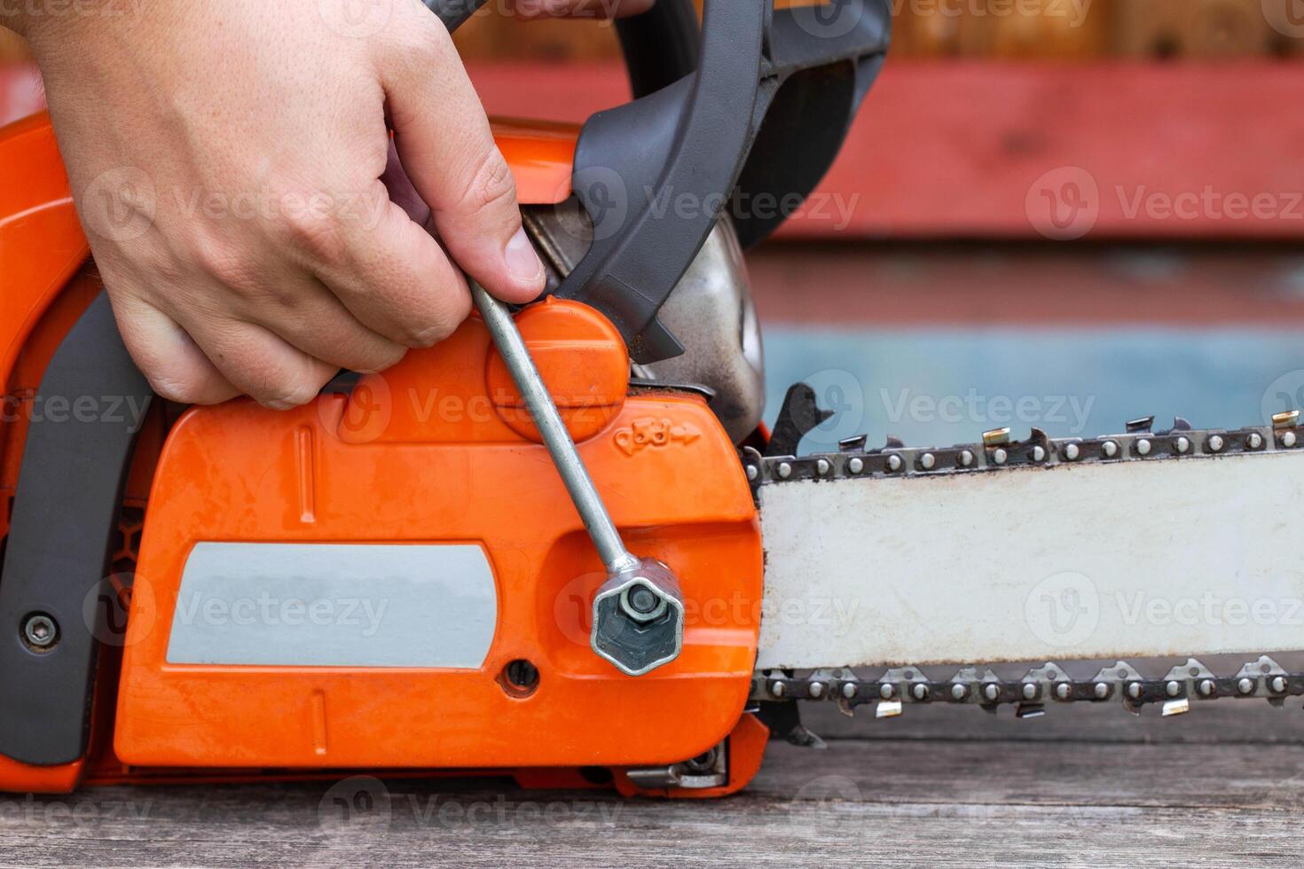 Correct chain tension using the special tool on the chainsaw bar. photo