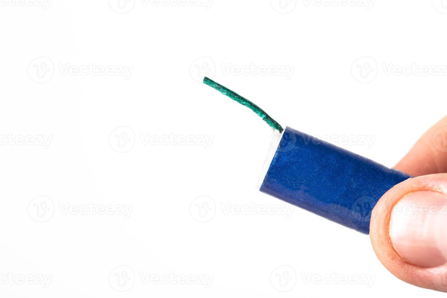 Firecracker with a wick in hand on a white background, isolate, close-up. Copy space for text. Fireworks Explosion Safety photo