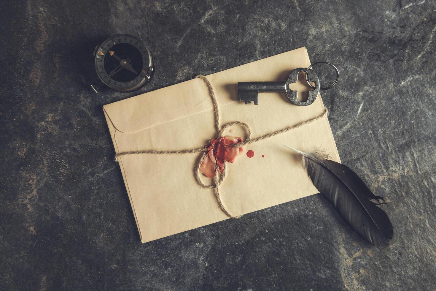An envelope with a key, a feather and a seal photo