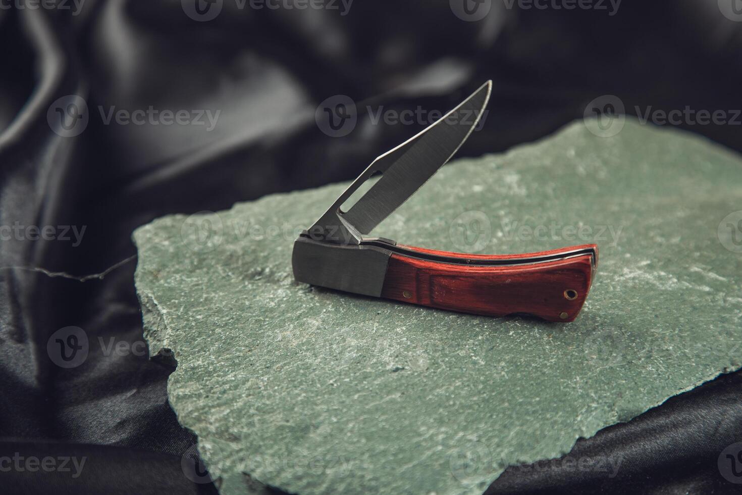 pocket knife on the stone photo